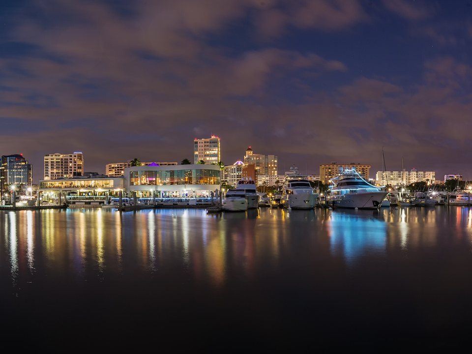 Downtown Sarasota skyline and marina reflected across the bay at night