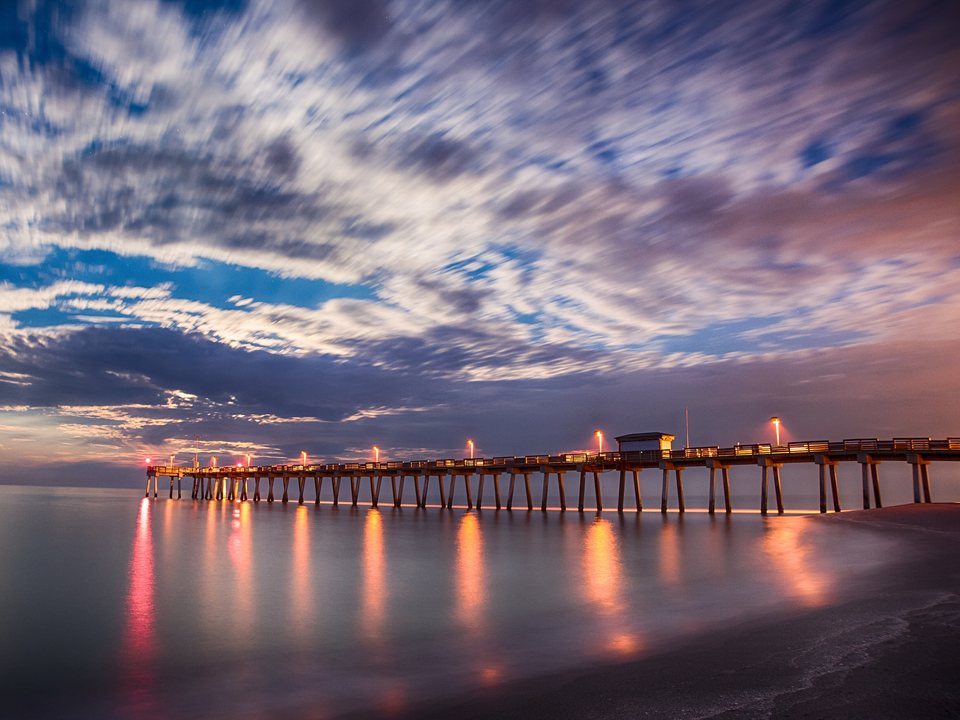 Venice Fishing Pier extending into the Gulf beneath a dramatic evening sky